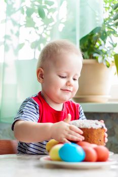 Portrait of a cute child with Easter eggs. Easter lunch. The feast of Holy Easter. Painted Easter eggs.