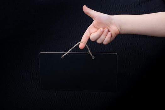 Rectangular shaped black notice board in hand on black background