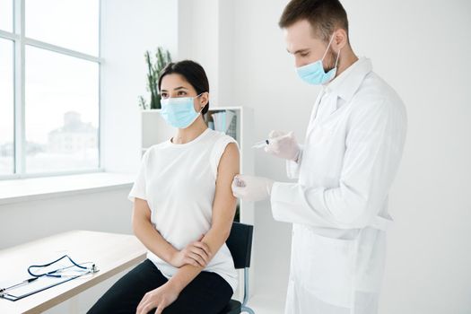 doctor and patient wearing medical masks covid-19 injection vaccination infection epidemic. High quality photo