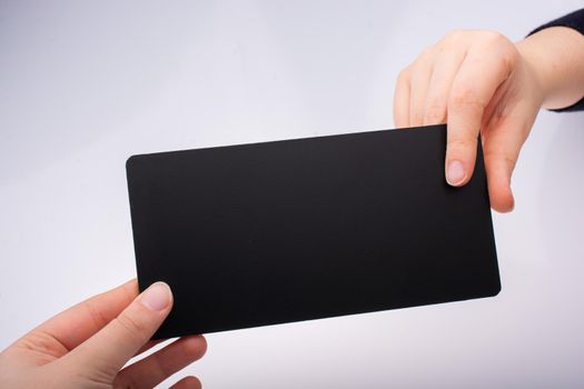 Rectangular shaped black notice board in hand on white background