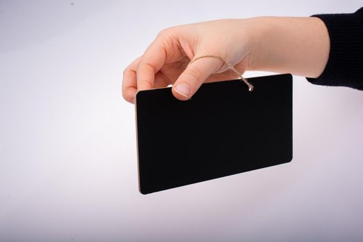 Rectangular shaped black notice board in hand on white background