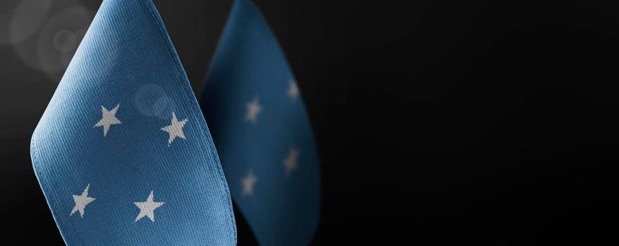 Small national flags of the Federated States Micronesia on a dark background.