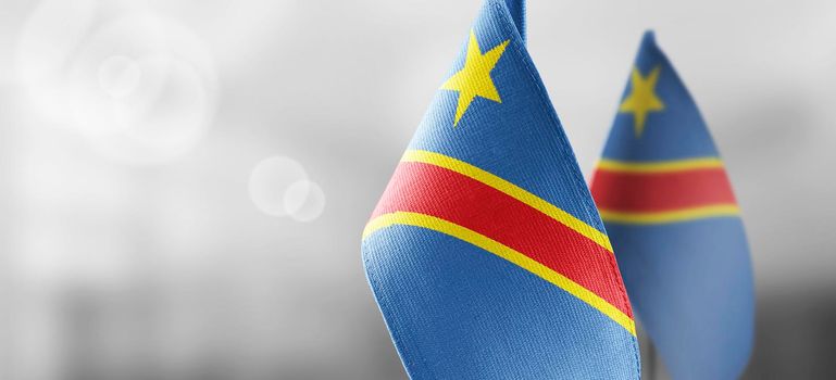 Small national flags of the Democratic Republic of the Congo on a light blurry background.