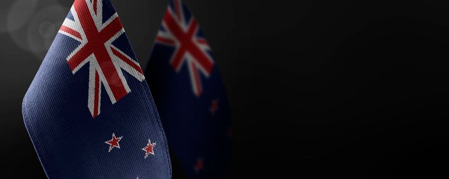 Small national flags of the New Zealand on a dark background.