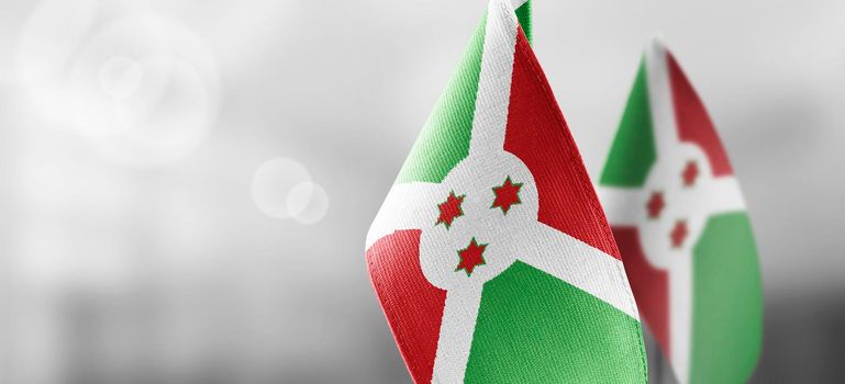 Small national flags of the Burundi on a light blurry background.