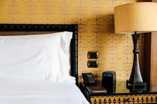 Image of Luxurious bedroom detail, furniture, lamp and accessories.