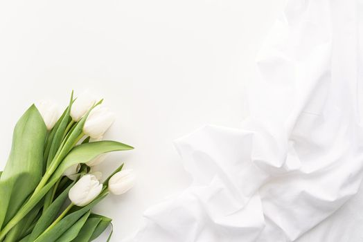 Spring concept. White tulip bouquet and fabric for mock up design on white background with copy space