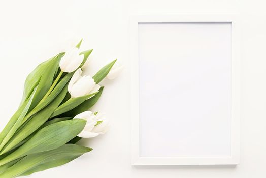 Spring concept. white tulip bouquet and blank frame for mock up design on white background with copy space