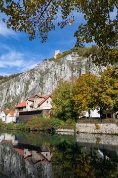 Idyllic view at the village Markt Essing in Bavaria, Germany with the Altmuehl river and high rocks on a sunny day in autumn