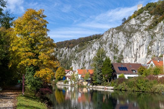 Idyllic view at the village Markt Essing in Bavaria, Germany with the Altmuehl river and high rocks on a sunny day in autumn