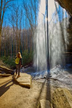 Woman standing near Moore Cove Waterfall in Pisgah National Forest near Brevard NC.