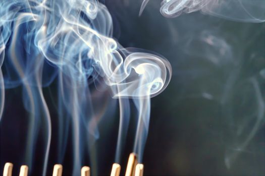 Burning incense, white smoke, black background, used as a worship background image, a sacred object of Buddhist beliefs, focus on the smoke.