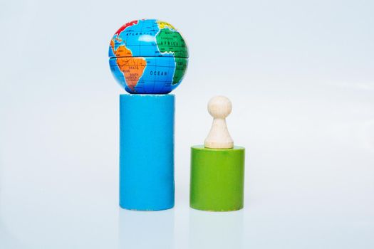 Wooden figurines of people aand a mini globe on white background