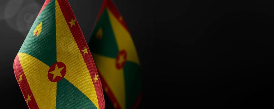 Small national flags of the Grenada on a dark background.