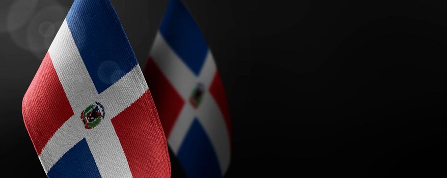 Small national flags of the Dominicana on a dark background.