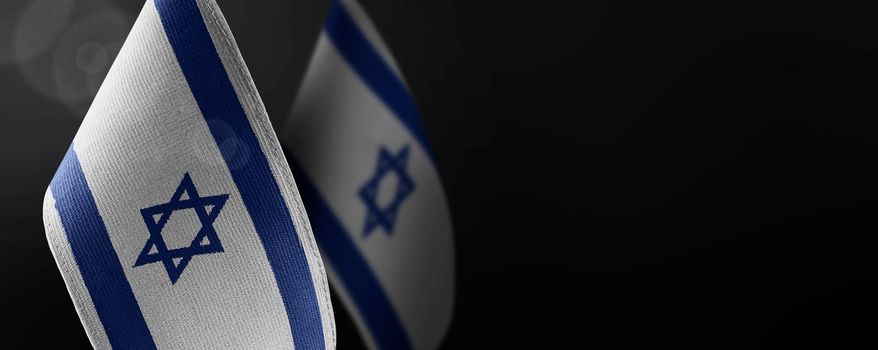 Small national flags of the Israel on a dark background.