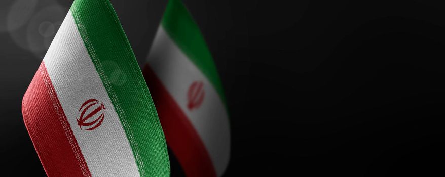 Small national flags of the Iran on a dark background.