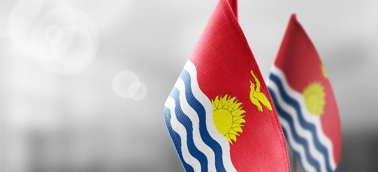 Small national flags of the Kiribati on a light blurry background.