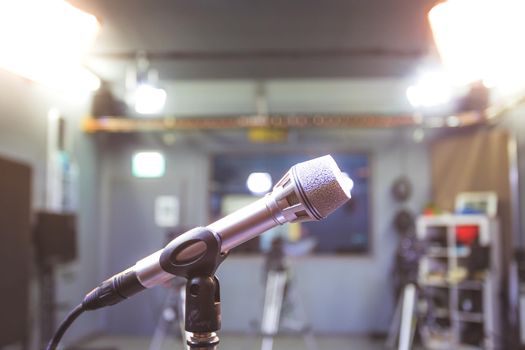 Professional microphone in recording tv studio, studio lights in blurry background