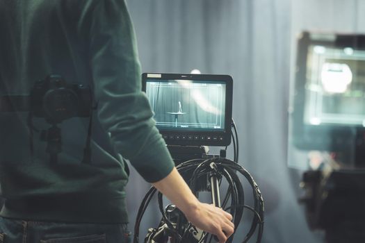 Male cameraman is operating a film camera in a television recording studio