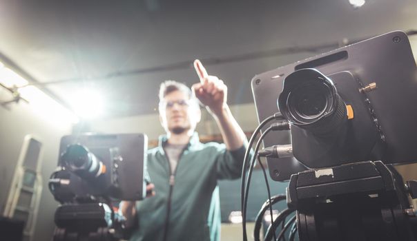 Male cameraman is operating a film camera in a television recording studio