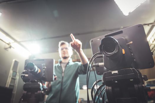 Male cameraman is operating a film camera in a television recording studio