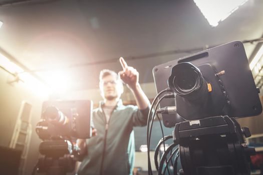 Male cameraman is operating a film camera in a television recording studio