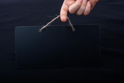 Rectangular shaped black notice board in hand on black background