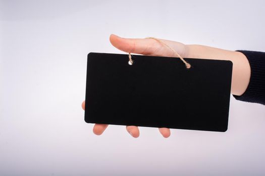 Rectangular shaped black notice board in hand on white background