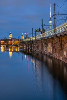 The River Spree, the Television Tower and a moving train in Berlin at dusk