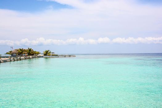 atoll of the tropics and maldives that are reflected in a sea of emerald with a cobalt blue sky