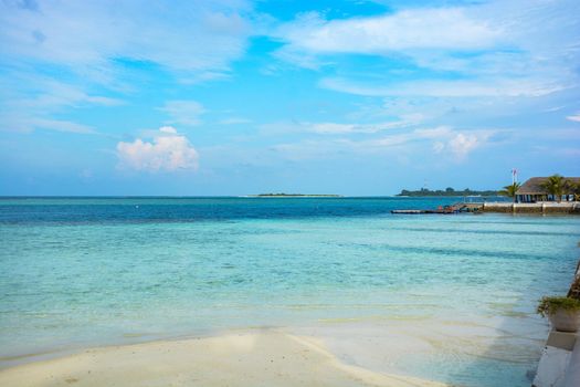 atoll of the tropics and maldives that are reflected in a sea of emerald with a cobalt blue sky