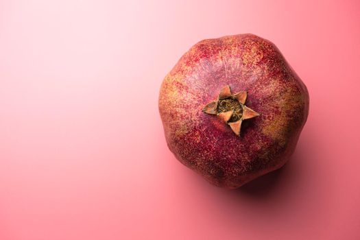 ripe pomegranate on a pink background. love. Fruit. High quality photo