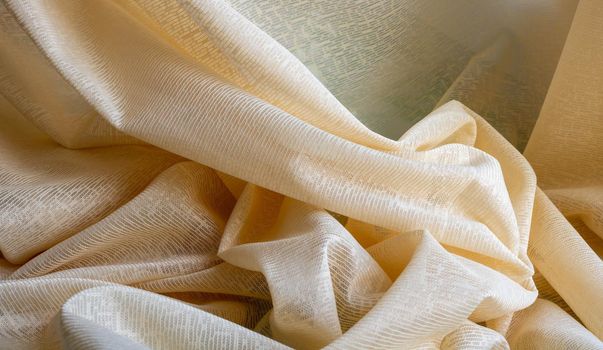 Beige tulle fabric background, seamless texture with beautiful close-up and elegant fabric background details. Luxury tulle textile pattern with soft vintage material.