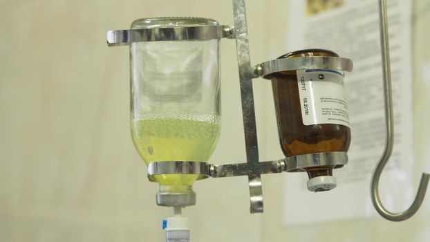 Dropper for intravenous injection. Apparatus and valve control for saline solution to patient. Infusion pump iv feeding.