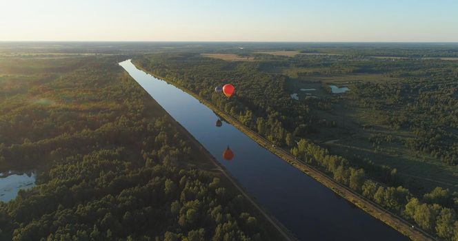 Aerial view Hot air balloons in sky over fields in countryside, beautiful sky and sunset. Aerostat fly over countryside.