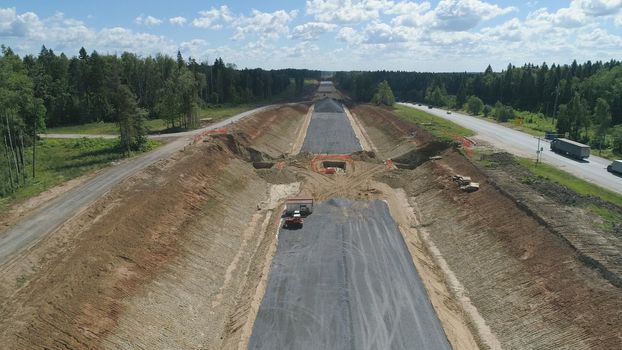 Construction of toll roads in rural areas. Aerial view construction of a new highway next to the old highway.