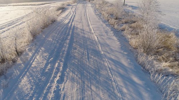 aerial view winter landscape countryside road through winter field with forest. winter forest on a sunny day. winter in countryside