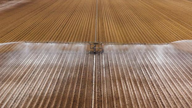 aerial view Center pivot agriculture irrigation machine of crops. An irrigation pivot watering agricultural land. Irrigation system watering farm land.