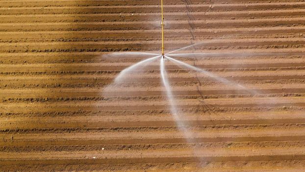 aerial view Center pivot agriculture irrigation machine of crops. An irrigation pivot watering agricultural land. Irrigation system watering farm land.