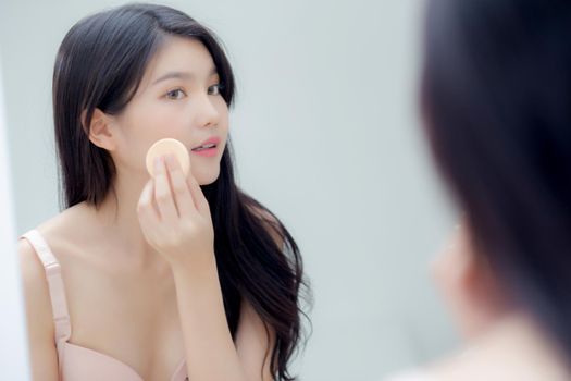 Closeup hand of young asian woman holding product cosmetic applying cream in jar, beautiful girl hand touch lotion for rejuvenation, beauty perfect, treatment and skin care and health concept.