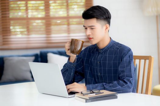 Young business man working from home with laptop computer on desk, freelance male sitting stay home using notebook for communication and relax on table, entrepreneur in startup business, new normal.