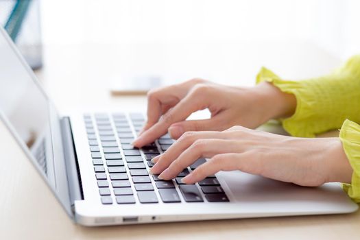 Closeup of hand young asian businesswoman working on laptop computer on desk at home office, freelance looking and typing on notebook on table, woman studying online, business and education concept.