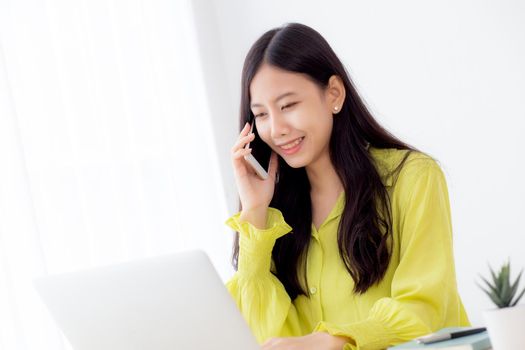 Young asian business woman working form home office and call phone for success at home, businesswoman using laptop computer on desk, female talking smartphone at workplace, communication concept.