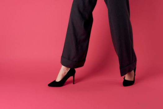 female legs black shoes glamor luxury pink background cropped view. High quality photo