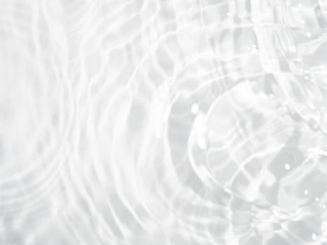 Blurred ripple water texture on white background. Shadow of water on sunlight. Mockup for product, spa or travel background. Marble water surface as wallpaper background