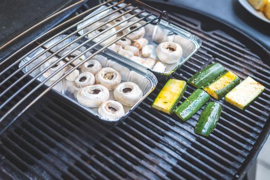 Close up of cheese and vegetables on gas grill. Summer time, outdoors.