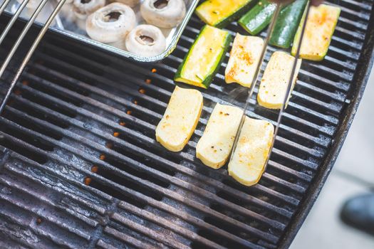 Close up of cheese and vegetables on gas grill. Summer time, outdoors.