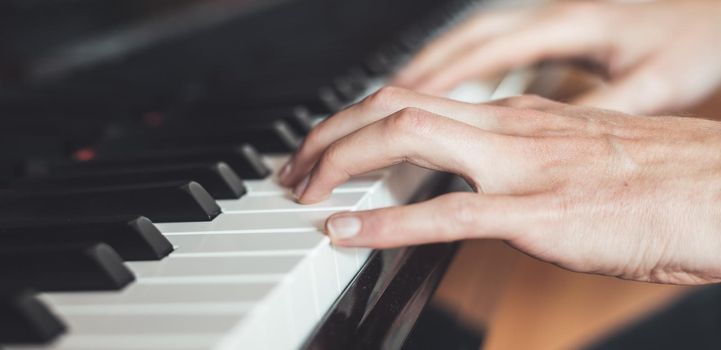 Man is playing piano at home. Clipping of piano and hands.