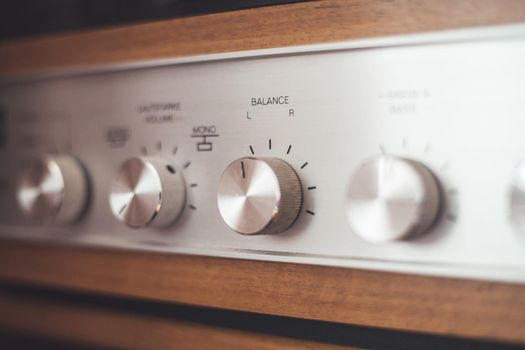 Control knops of silver wooden vintage amplifier, closeup
